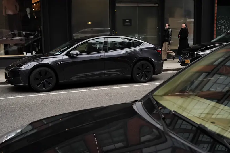 People walk past a Tesla car parked in the Meatpacking District of New York City, U.S., January 02, 2025. REUTERS/Adam Gray/File Photo