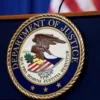 The seal of the U.S. Justice Department is seen on the podium in the Department's headquarters briefing room before a news conference with the Attorney General in Washington, January 24, 2023. REUTERS/Kevin Lamarque//File Photo