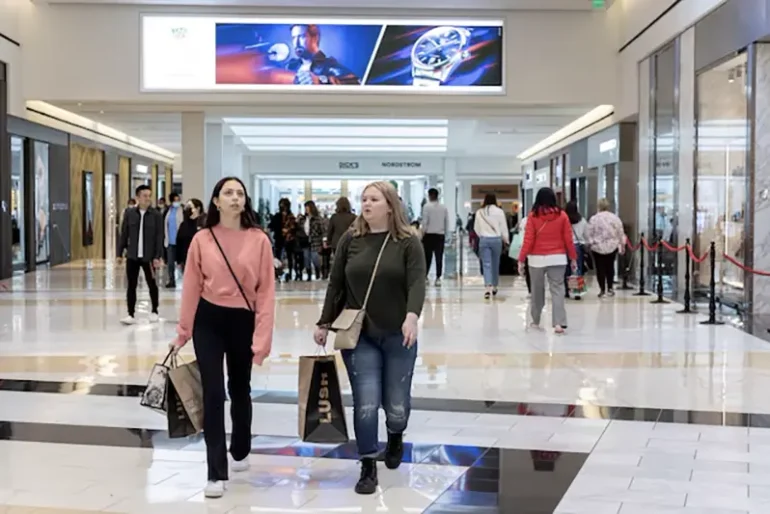 People carrying shopping bags walk inside the King of Prussia shopping mall in King of Prussia, Pennsylvania, U.S. November 26, 2021. REUTERS/Rachel Wisniewski/File Photo