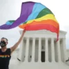 WASHINGTON, DC - JUNE 15: Joseph Fons holding a Pride Flag in front of the U.S. Supreme Court building after the court ruled that LGBTQ people can not be disciplined or fired based on their sexual orientation, Washington, DC, June 15, 2020. With Chief Justice John Roberts and Justice Neil Gorsuch joining the Democratic appointees, the court ruled 6-3 that the Civil Rights Act of 1964 bans bias based on sexual orientation or gender identity. Fons is wearing a Black Lives Matter mask with the words 'I Can't Breathe', as a precaution against Covid-19. (Photo by Chip Somodevilla/Getty Images)