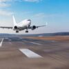 Airplane landing on runway under clear blue sky