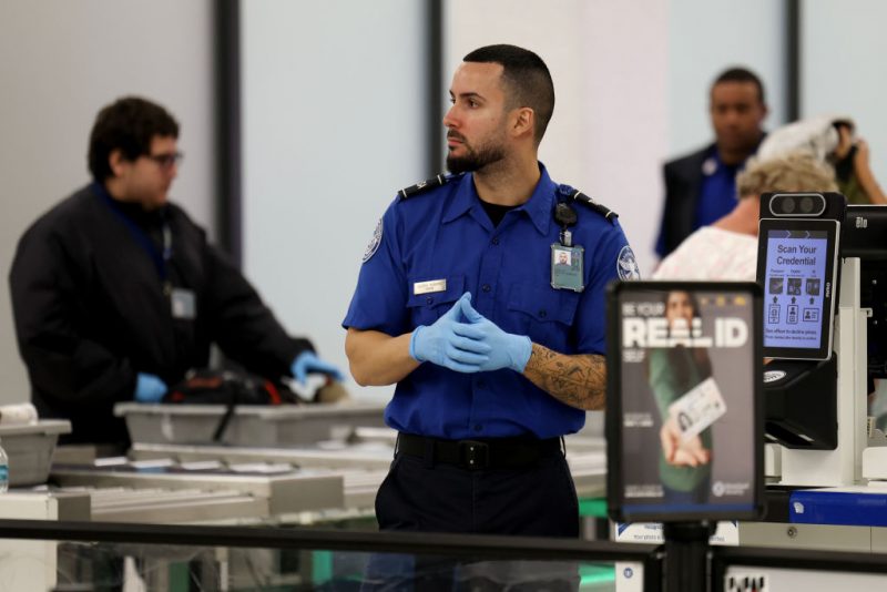 MIAMI, FLORIDA - DECEMBER 20: A TSA agent works in a TSA Pre checkpoint at the Miami International Airport as some of the year's busiest travel days occur during the holiday season on December 20, 2024 in Miami, Florida. As the U.S. government works to pass a new funding resolution, some travelers fear that if the government shuts down, they will endure longer lines at airports as some security staffers and air traffic controllers would not be getting paid and could choose not to report to work. Transportation Security Administration (TSA) workers are deemed essential, meaning they must stay on the job even if the government shuts down (Photo by Joe Raedle/Getty Images)