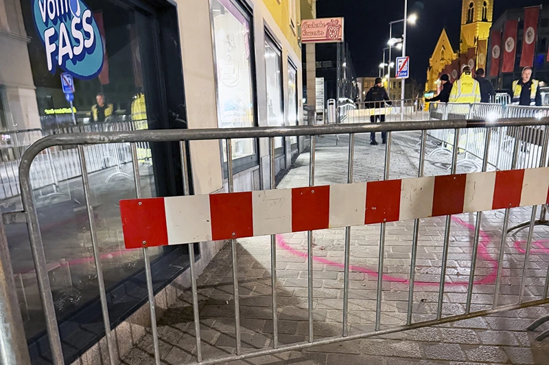 Candles are lit near a police barrier after a knife attack near the main square in the city centre of Villach, southern Austria on February 15, 2025. A 14-year-old boy died and four other people were injured in the knife attack in southern Austria on February 15, police said, adding they have arrested a 23-year-old Syrian asylum seeker. (Photo by GERD EGGENBERGER / APA / AFP) / Austria OUT (Photo by GERD EGGENBERGER/APA/AFP via Getty Images)