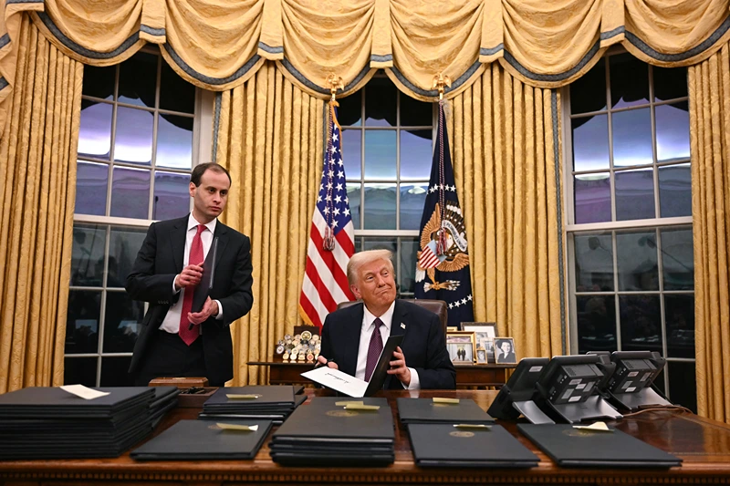 TOPSHOT - US President Donald Trump signs executive orders in the Oval Office of the WHite House in Washington, DC, on January 20, 2025. (Photo by Jim WATSON / AFP) (Photo by JIM WATSON/AFP via Getty Images)