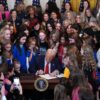 WASHINGTON, DC - FEBRUARY 05: U.S. President Donald Trump joined by women athletes signs the “No Men in Women’s Sports” executive order in the East Room at the White House on February 5, 2025 in Washington, DC. The executive order, which Trump signed on National Girls and Women in Sports Day, prohibits transgender women from competing in women’s sports and is the third order he has signed that targets transgender people. (Photo by Andrew Harnik/Getty Images)