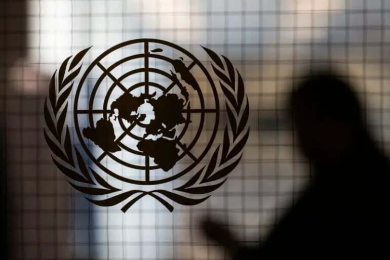 A person walks past the UN logo at UN headquarters on February 8 , 2024, in New York. (Photo by ANGELA WEISS / AFP) (Photo by ANGELA WEISS/AFP via Getty Images)