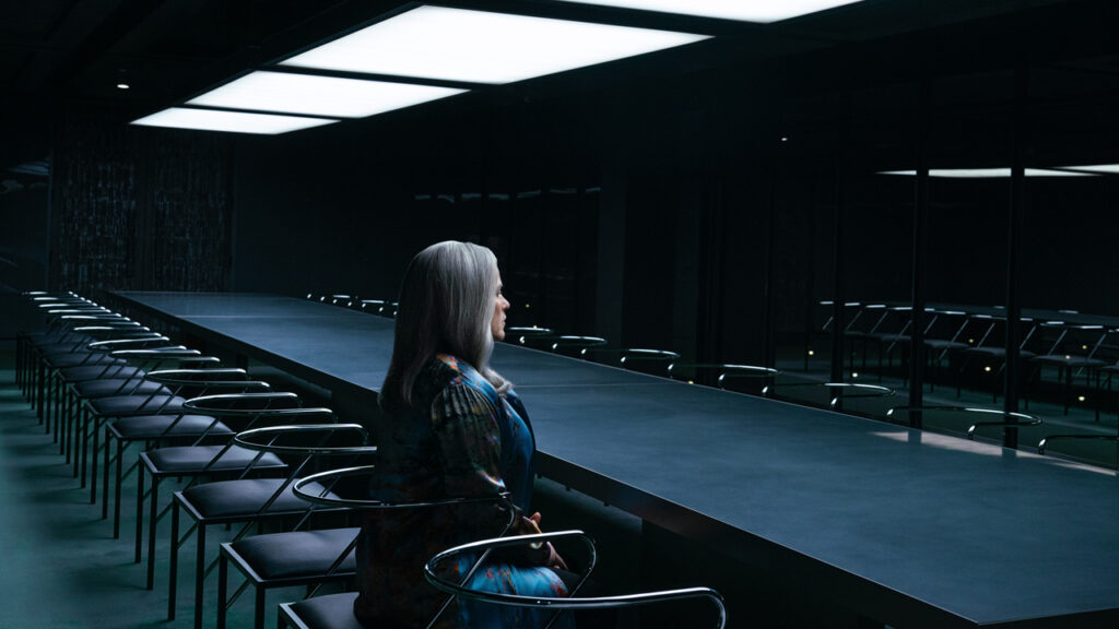 Harmony Cobel sitting alone in a meeting room in Severance season 2