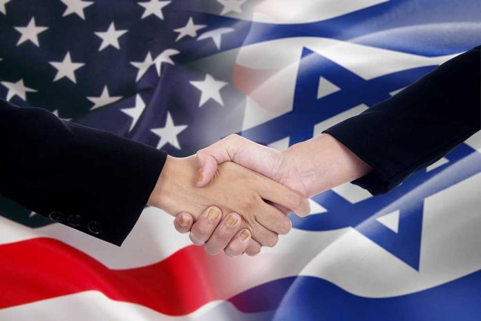 Handshake with USA and Israel flags background.