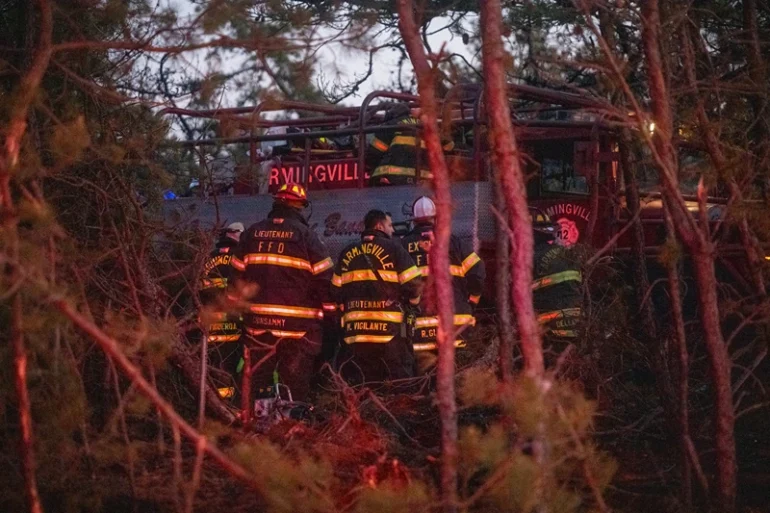 Firefigters assemble around rescue units while putting out fires on March 8, 2025 in Westhampton, New York. As strong winds fueled multiple brush fires on New York's Long Island, closing roads and reportedly burning structures. (Photo by Andrew Theodorakis/Getty Images)