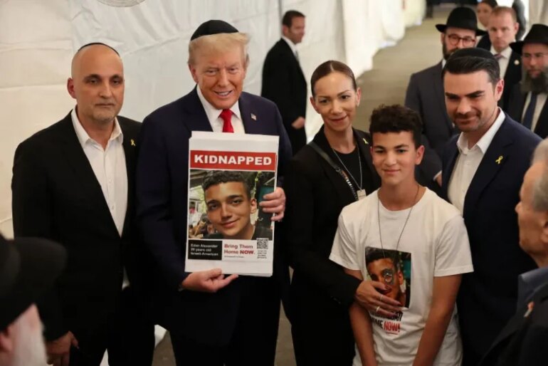 NEW YORK, NEW YORK - OCTOBER 07: Republican presidential nominee, former U.S. President Donald Trump, poses for photos with the family of Edan Alexander at Ohel Chabad Lubavitch on October 07, 2024 in New York City. Trump commemorated the one-year anniversary of October 7th by visiting to Ohel Chabad Lubavitch, the final resting place of Rabbi Menachem M. Schneerson the Rebbe, with the family of Edan Alexander, who was taken hostage by Hamas on October 7th, in attendance. On October 7, the Palestinian militant group Hamas launched a surprise attack on Israel from Gaza by land, sea, and air, killing more than 1,200 people and taking Israeli soldiers and civilians hostage. To date, there are over 90 people still being held hostage by Hamas. (Photo by Michael M. Santiago/Getty Images)