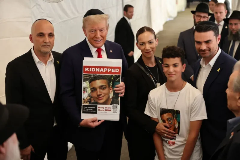 NEW YORK, NEW YORK - OCTOBER 07: Republican presidential nominee, former U.S. President Donald Trump, poses for photos with the family of Edan Alexander at Ohel Chabad Lubavitch on October 07, 2024 in New York City. Trump commemorated the one-year anniversary of October 7th by visiting to Ohel Chabad Lubavitch, the final resting place of Rabbi Menachem M. Schneerson the Rebbe, with the family of Edan Alexander, who was taken hostage by Hamas on October 7th, in attendance. On October 7, the Palestinian militant group Hamas launched a surprise attack on Israel from Gaza by land, sea, and air, killing more than 1,200 people and taking Israeli soldiers and civilians hostage. To date, there are over 90 people still being held hostage by Hamas. (Photo by Michael M. Santiago/Getty Images)