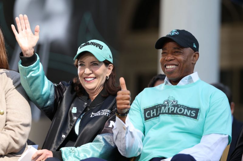 NEW YORK, NEW YORK - OCTOBER 24: Governor of New York Kathy Hochul (L) and New York City Mayor Eric Adams react on stage during the New York Liberty Championship ticker tape parade celebrating winning the 2024 WNBA Finals on October 24, 2024 in New York City. NOTE TO USER: User expressly acknowledges and agrees that, by downloading and/or using this photograph, user is consenting to the terms and conditions of the Getty Images License Agreement. (Photo by Elsa/Getty Images)