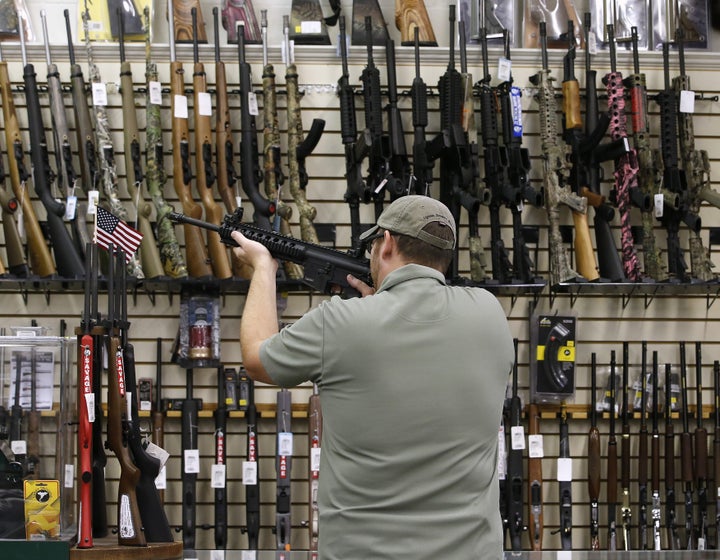 A customer holds an AR-15 rifle for sale at a gun store in Orem, Utah, in 2016.