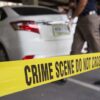 Crime scene tape near a white car