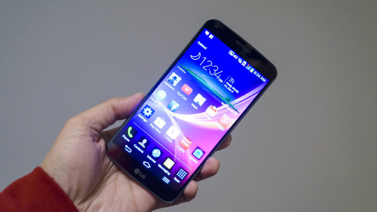 A hand holding the LG G Flex phone