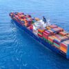 Cargo ship carrying colorful containers in open sea