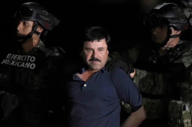 TOPSHOT - Drug kingpin Joaquin "El Chapo" Guzman is escorted into a helicopter at Mexico City's airport on January 8, 2016 following his recapture during an intense military operation in Los Mochis, in Sinaloa State. Mexican marines recaptured fugitive drug kingpin Joaquin "El Chapo" Guzman on Friday in the northwest of the country, six months after his spectacular prison break embarrassed authorities. AFP PHOTO / ALFREDO ESTRELLA (Photo by ALFREDO ESTRELLA / AFP) (Photo by ALFREDO ESTRELLA/AFP via Getty Images)