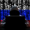 Hacker in hoodie with Russian flag background and code