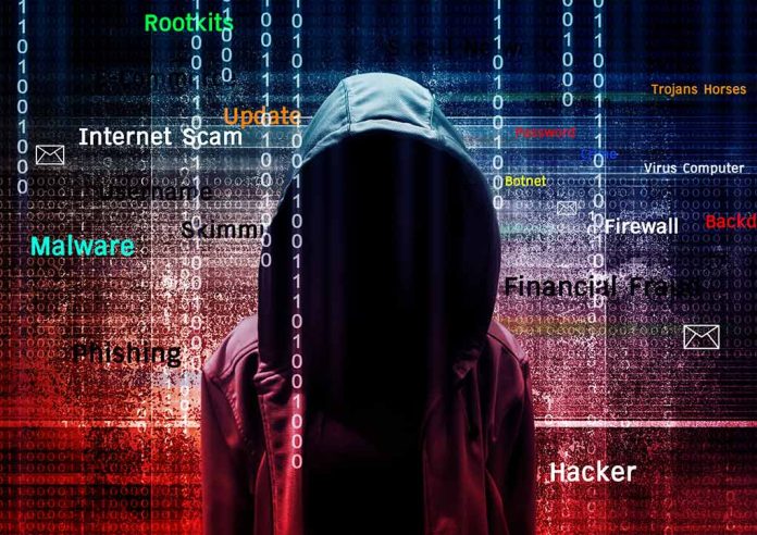 Hooded figure with digital security terms background