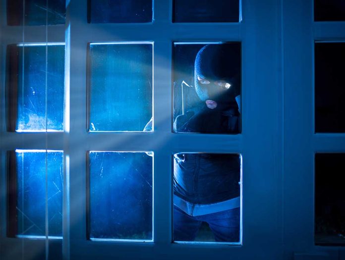 Masked figure peering through glass door at night