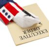 Gloved hand writing executive order labeled paper