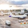Airport with airplanes runway and terminal at sunset