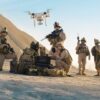 Soldiers operating drone in desert landscape with equipment