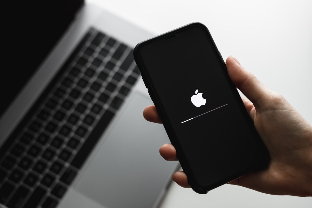 Hand holding an iPhone displaying iOS firmware update process, Rostov-on-Don, Russia, dated 22 May 2020