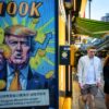 Cryptocurrency exchange office in Hong Kong with a screen featuring President Trump holding cryptocurrency coins.