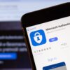 Microsoft Authenticator app logo on phone screen.
