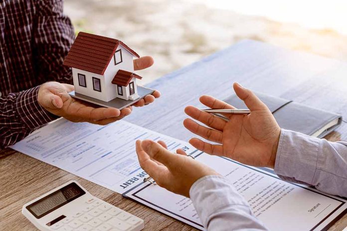 Hands exchanging miniature house over contracts