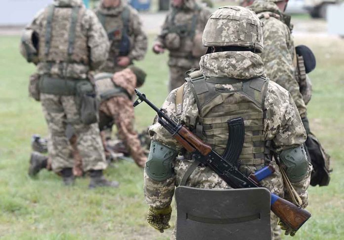 Soldiers in camouflage gear gathered on grass field