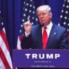 Person speaking at podium with multiple American flags