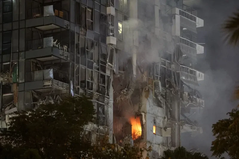 TOPSHOT - Fire and smoke rise from a building, reportedly hit by a missile fired from Iran, in central Tel Aviv on June 13, 2025. Iran fired a barrage of ballistic missiles at Israel in a counter-strike in the evening on June 13, after an unprecedented onslaught hammered the Islamic republic's top military brass and targeted its nuclear facilities and bases. (Photo by Jack GUEZ / AFP) (Photo by JACK GUEZ/AFP via Getty Images)