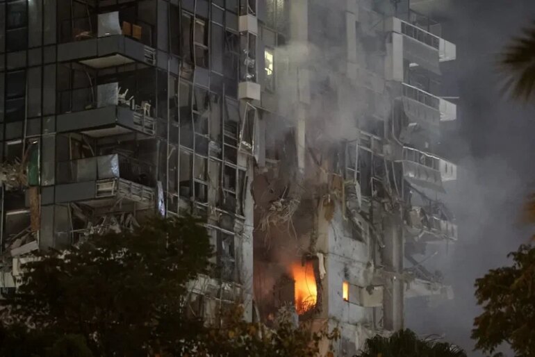 TOPSHOT - Fire and smoke rise from a building, reportedly hit by a missile fired from Iran, in central Tel Aviv on June 13, 2025. Iran fired a barrage of ballistic missiles at Israel in a counter-strike in the evening on June 13, after an unprecedented onslaught hammered the Islamic republic's top military brass and targeted its nuclear facilities and bases. (Photo by Jack GUEZ / AFP) (Photo by JACK GUEZ/AFP via Getty Images)