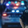 Police officer with patrol car and flashing lights