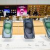 iPhone 15 and iPhone 15 Plus models displayed in an Apple Store.