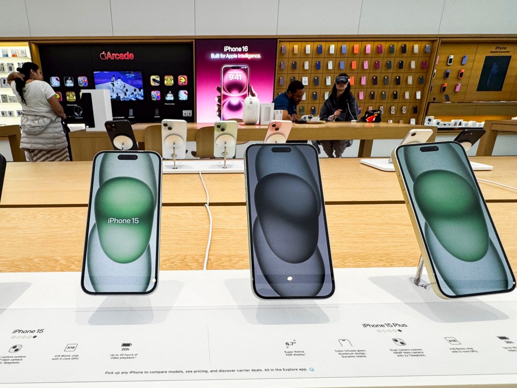 iPhone 15 and iPhone 15 Plus models displayed in an Apple Store.