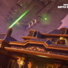 A Star Destroyer fires huge green laser beams above a golden guided manor house