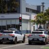 Two Waymo self-driving cars stopped at a traffic light.