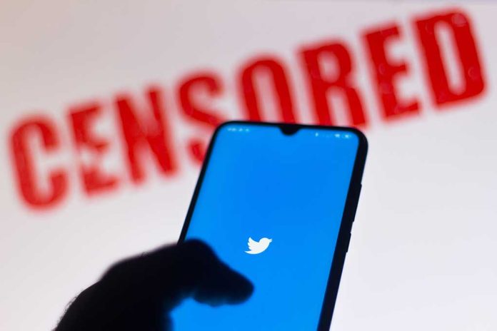 Phone displaying Twitter app with CENSORED in background