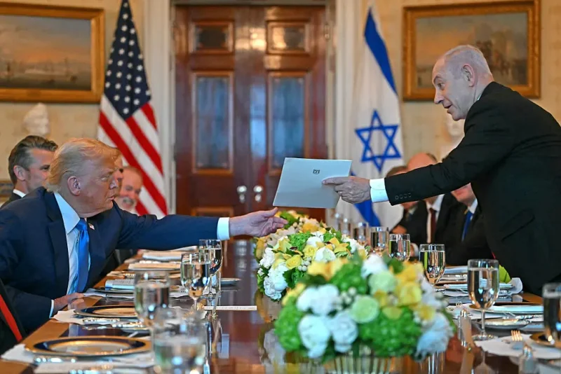 Israeli Prime Minister Benjamin Netanyahu (R) hands over a letter to US President Donald Trump as they meets at the Blue Room of the White House in Washington, DC, on July 7, 2025. Prime Minister Netanyahu will meet Monday with President Trump, who expressed hope for a "deal this week" between Israel and Hamas that sees hostages released from the Gaza Strip. Indirect negotiations between Israel and Hamas began on July 6 in Doha, aiming to broker a ceasefire and reach an agreement on the release of hostages in exchange for Palestinian prisoners. (Photo by ANDREW CABALLERO-REYNOLDS / AFP) (Photo by ANDREW CABALLERO-REYNOLDS/AFP via Getty Images)