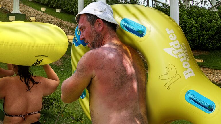 Satire news: dad carrying 2 person inner tube up waterslide steps