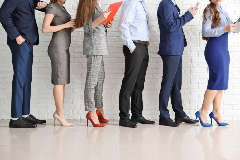 Businesspeople waiting in line indoors.