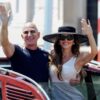 Jeff Bezos and Lauren Sanchez Bezos waving from a boat in Venice.