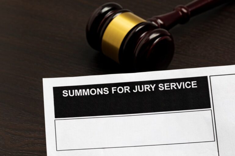 Summons for jury service with gavel in background.