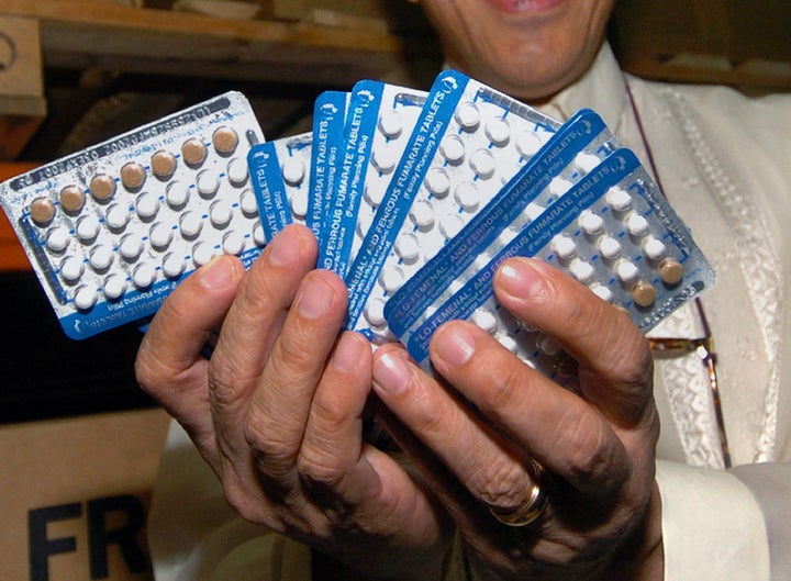 Former Manila Health Secretary Manuel Dayrit shows packs of "family planning pills" being prepared for distribution in Manila as part of $3.5 million assistance from the USAID and the U.N. Population Fund in 2004.