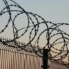 Barbed wire fence against sunset sky background