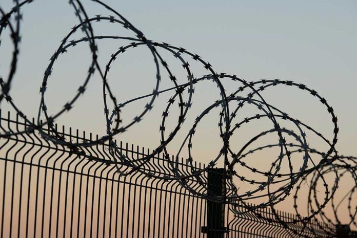 Barbed wire fence against sunset sky background
