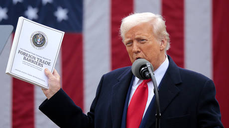 US President Donald Trump holds up a copy of a 2025 National Trade Estimate Report as he speaks during a 'Make America Wealthy Again' trade announcement event in the Rose Garden at the White House on April 2, 2025 in Washington, DC.